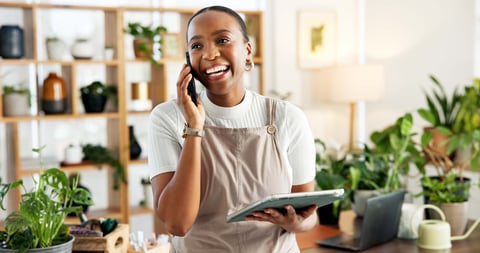 Woman florist on phone for online order confirmation